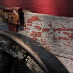 photo of a rusty red hinge and a wagon wheel