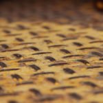 photos of peeling yellow paint on diamond plate metal from a piece of heavy equipment