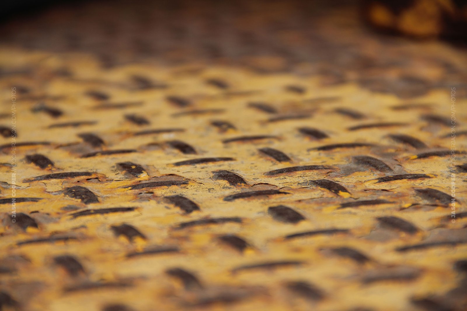 photos of peeling yellow paint on diamond plate metal from a piece of heavy equipment